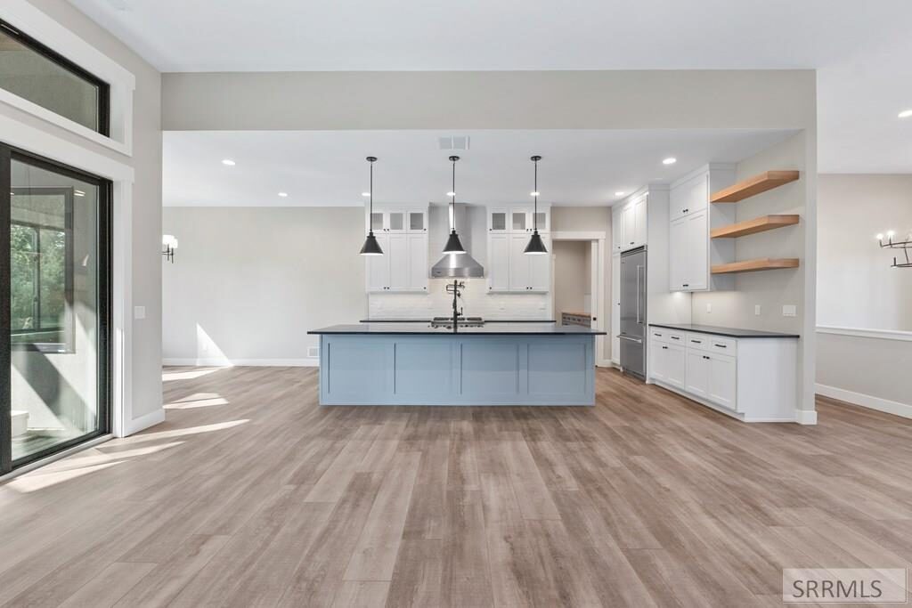 Open kitchen and living area with blue island and white cabinetry