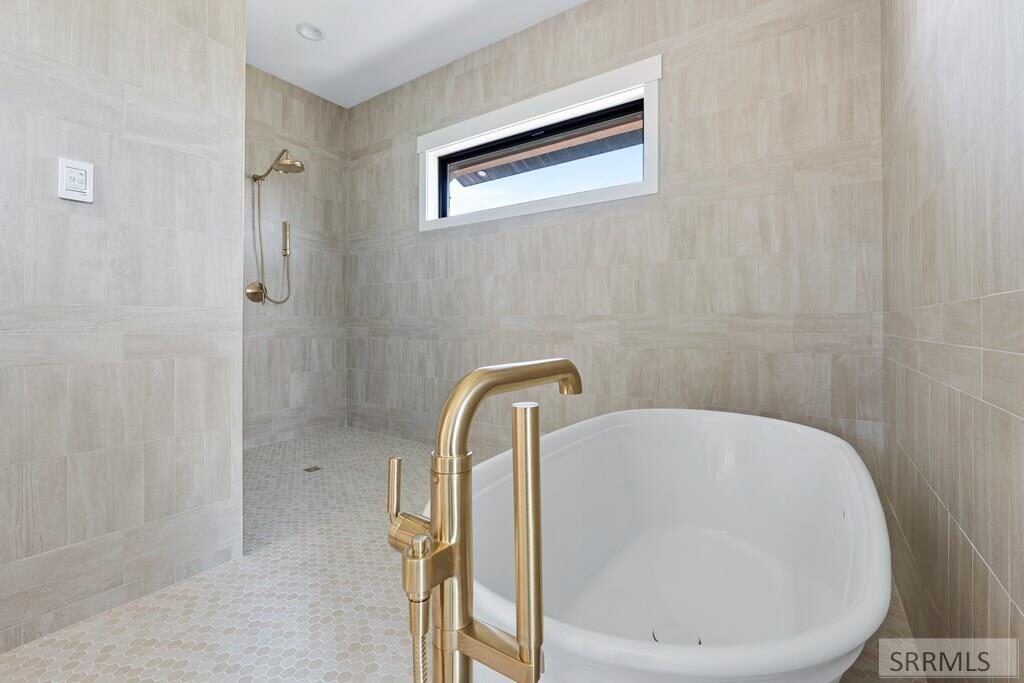 Spa bathroom with freestanding tub and gold fixtures